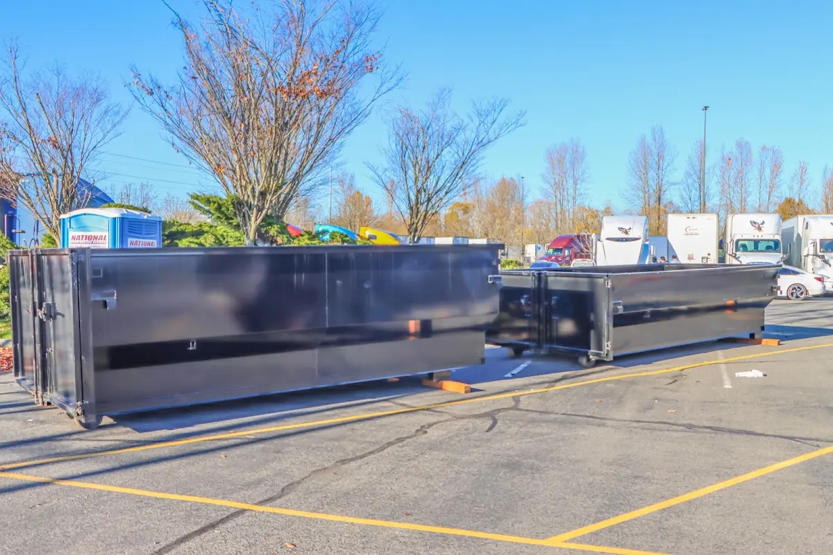 Professional dumpster rental service with roll-off container on residential driveway in Alameda